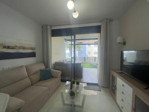 a living room with a couch and a television at 2 bedroom infinity beach. in Mazarrón