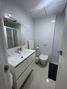 La salle de bains blanche est pourvue d'un lavabo et de toilettes. dans l'établissement 2 bedroom infinity beach., à Mazarrón