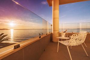einen Balkon mit einem Tisch, einem Stuhl und Meerblick in der Unterkunft Hotel Garbi Ibiza & Spa in Playa d'en Bossa