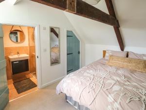 a bedroom with a bed and a bathroom with a sink at The Loft in Plymouth