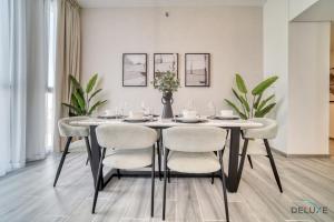comedor con mesa y sillas en Refined 2BR with Assistant Room at Mesk 1 Midtown Dubai Production City by Deluxe Holiday Homes en Dubái