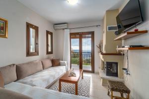 a living room with a couch and a fireplace at Villa Angela in Skiathos