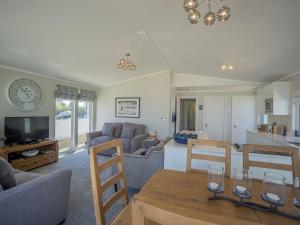 a living room with a couch and a table at E19 The Warren in Pwllheli