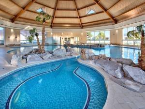 a pool in a resort with a swimming pool with rocks at E19 The Warren in Pwllheli