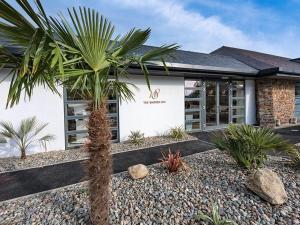 a palm tree in front of a building at E19 The Warren in Pwllheli