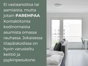 Hiisi Homes Espoo Center في إسبو: غرفة معيشة بيضاء مع أريكة ونافذة