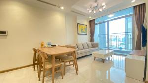 胡志明市的住宿－123 Apartment in Vinhomes Central Park - Landmark 81，客厅配有桌子和沙发
