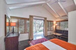 1 dormitorio con 1 cama y escritorio en una habitación en Nguni Lodge, en Hluhluwe