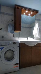 La salle de bains est pourvue d'un lave-linge et d'un lavabo. dans l'établissement Corinas Holiday House, à La Canée