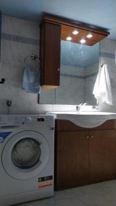 uma casa de banho com uma máquina de lavar roupa e um lavatório em Corinas Holiday House em Chania Town