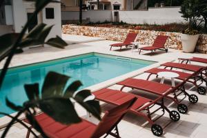 a swimming pool with chairs and a table and a group at Le canne Pool and Relax in Pulsano