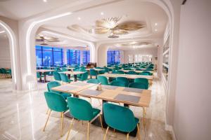 une salle à manger avec des tables et des chaises vertes dans l'établissement Bacolux Afrodita Resort & SPA, Herculane, à Băile Herculane