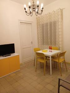 comedor con mesa blanca y sillas amarillas en Soffio di Mediterraneo appartamento, en Trapani