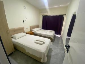 a room with two beds and a window at Beyoglu Pansiyon in Patara