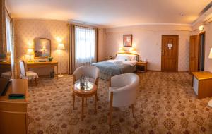 une chambre d'hôtel avec un lit, une table et des chaises dans l'établissement Continental Hotel, à Oulan-Bator