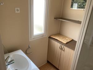 a bathroom with a sink and a window at Le bonheur est dans le pré. in Le Tréport