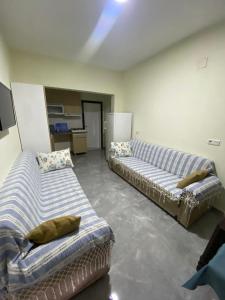 a living room with two couches in a room at Beyoglu Pansiyon in Patara