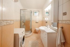 馬卡爾斯卡的住宿－盧斯別墅公寓，浴室配有卫生间水槽和淋浴。
