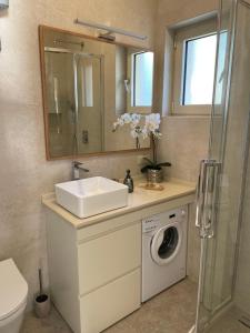 een badkamer met een wastafel en een wasmachine bij Point of View in Kotor