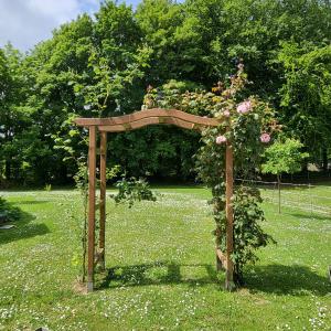 een houten boog met bloemen erop in een veld bij Chez Kate et lolo in Senneville-sur-Fécamp