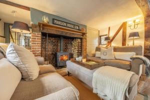 ein Wohnzimmer mit 2 Sofas und einem Kamin in der Unterkunft Well Green Cottage in Wenhaston