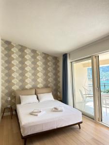 een slaapkamer met een wit bed en een balkon bij Point of View in Kotor