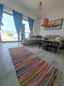 a living room with a rug and a couch and a table at the Queen Freddy Penthouse in Taʼ Xbiex