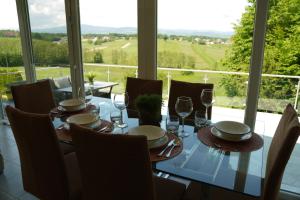 een eetkamer met een tafel met wijnglazen bij Sofia Holiday Haven in Nature with Pool in Slovenska Bistrica