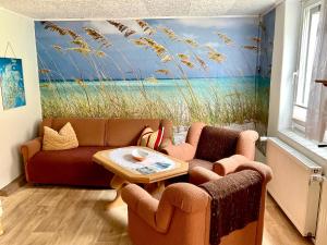 una sala de estar con 2 sofás y una pintura de una playa en Ruegen_Fewo 65, en Garz