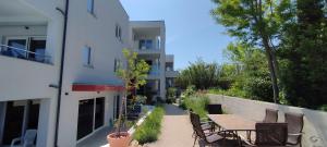 a patio with a table and chairs next to a building at Aparthotel Dalmacija in Privlaka