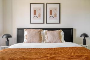 ein Schlafzimmer mit einem Bett mit zwei Bildern an der Wand in der Unterkunft Ballston 1BR w gym pool near Restaurants WDC-601 in Arlington + 19 Fotos