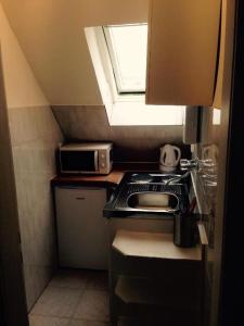 a small kitchen with a stove and a window at Kölner Pension Apartments in Cologne