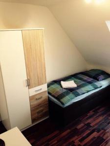 ein kleines Schlafzimmer im Dachgeschoss mit einem Bett und einem Spiegel in der Unterkunft Kölner Pension Apartments in Köln