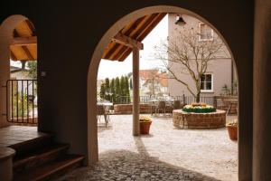 une arche menant à une terrasse avec une table et des chaises dans l'établissement Consulat des Weins, à Sankt Martin