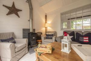 a living room with a couch and a wood stove at Well Green Cottage in Wenhaston