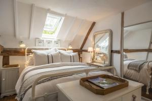 Schlafzimmer mit einem Bett mit einem Spiegel und einem Tisch in der Unterkunft Well Green Cottage in Wenhaston