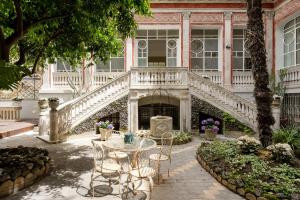 a patio with a table and chairs in front of a building at Artemisia Domus - Giardino in Naples