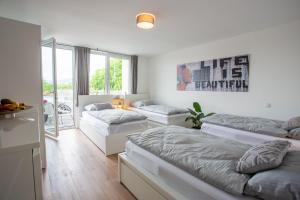 a bedroom with three beds and a balcony at City-House-Achern in Achern
