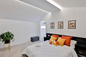 Dormitorio blanco con cama con almohadas coloridas en Casa Rural Atabe Etxea, 