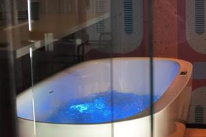 eine Badewanne mit blauem Wasser in einem Zimmer in der Unterkunft Salt Island Apartments in Kołobrzeg