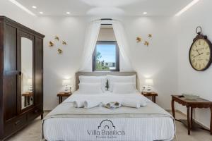 a bedroom with a large bed with a clock on the wall at Villa Basilica Tefsia in Perivolos