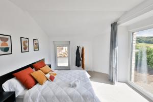 a white bedroom with a large bed with orange pillows at Casa Rural Atabe Etxea 