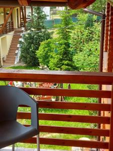 a balcony with a chair and a view of a yard at Casa Lia Figa in Beclean
