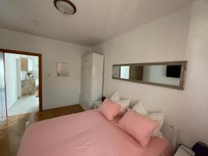 um quarto com uma cama rosa e um espelho em Apartment Kati em Crikvenica