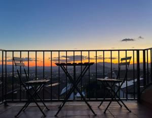 un tavolo e sedie su un balcone con vista sul tramonto di Luminosa y confortable casa con vistas y piscina a Jun