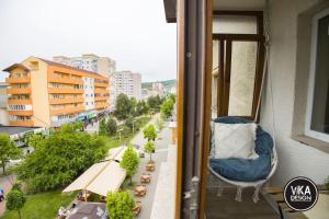 a chair on a balcony with a view of a city at Bulevard Apartments 11 in Alba Iulia