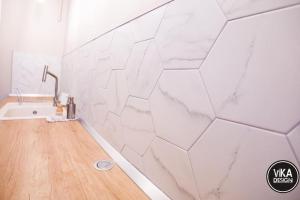a bathroom with white tiles on the wall at Bulevard Apartments 11 in Alba Iulia +33 photos