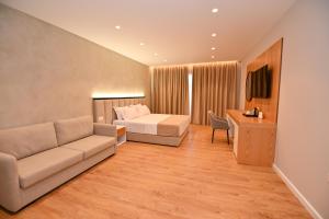 um quarto de hotel com uma cama e um sofá em Hotel Zanzi em Durrës