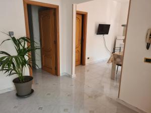 um corredor com um vaso de plantas num piso de azulejo em Venere Home em Metaponto