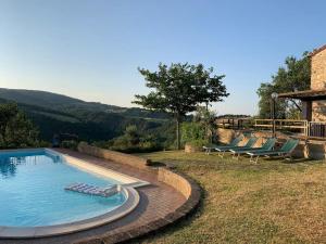 a swimming pool with two lounge chairs in a yard at Holiday home Garetto in Chianni